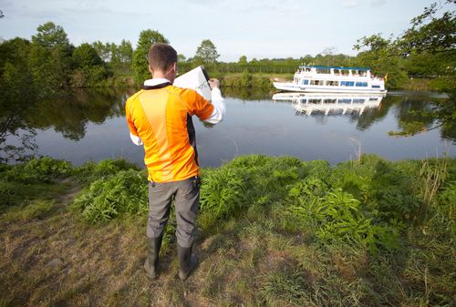 photo showing a moment from the piece “Schwalbe”, which was performed on and by a small river